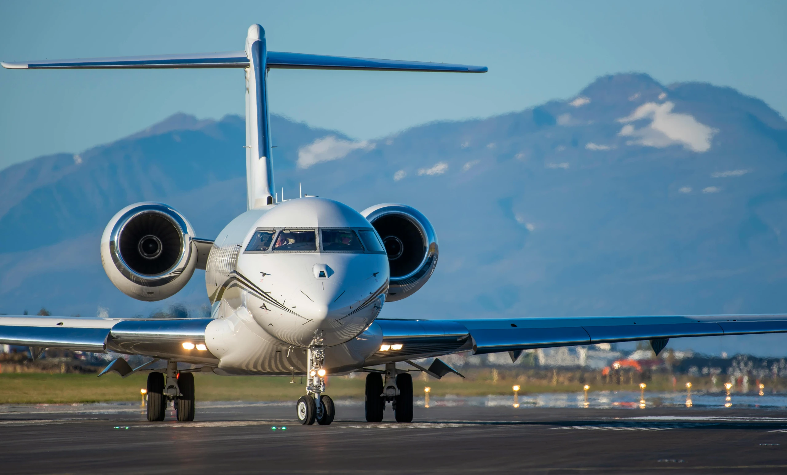 Private jet on runway with mountains in background